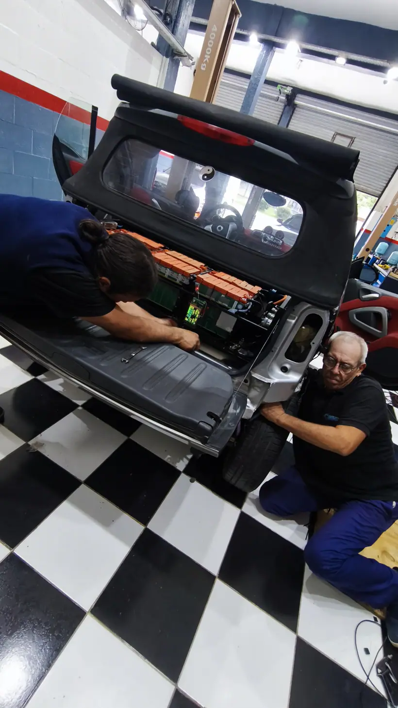 Dos personas instalando el pack en la parte trasera del cabrio
