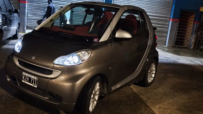 El Smart de noche con la capota abierta y el interior rojo